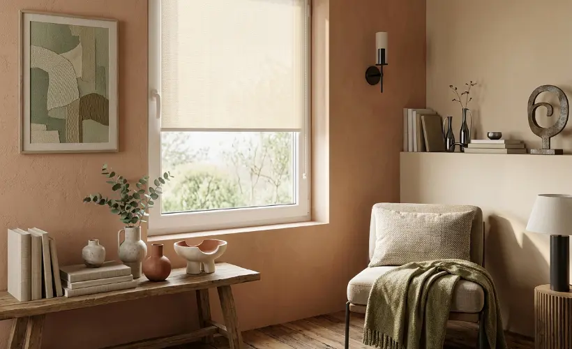A cozy corner in a modern living room in the colors of 2026, with a window and standard roller blind in a cream shade.