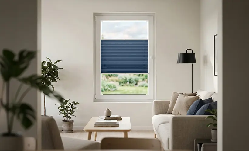 A bright interior with a navy pleated blind, wooden furniture, and subtle black accents